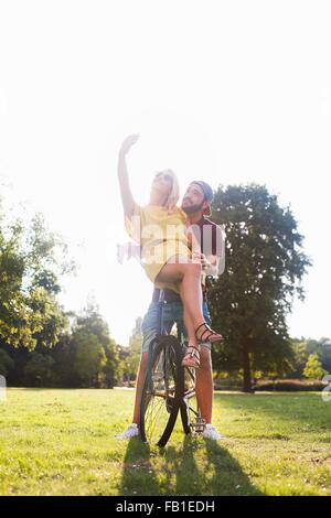 Junges Paar auf sonnenbeschienenen Park Smartphone Selfie am Fahrrad Stockfoto