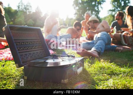 Erwachsenen Freunden entspannen und anhören von Rekord Deck im sunset Park feiern Stockfoto