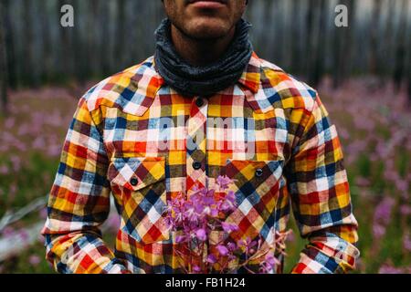 Verkürzten Blick auf Mitte erwachsenen Mannes tragen überprüft Shirt mit Wildblumen, Moraine Lake, Banff Nationalpark, Alberta Kanada Stockfoto