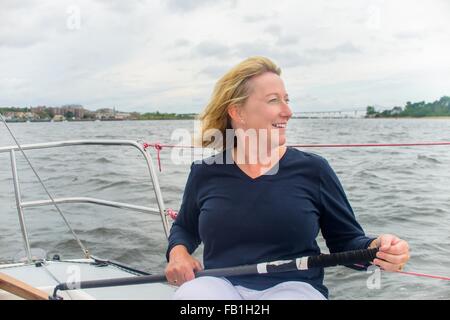 Reife Frau Lenkung Segelboot suchen Sie lächelnd Stockfoto