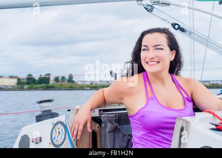 Junge Frau mit Weste auf Segelboot suchen Sie lächelnd Stockfoto