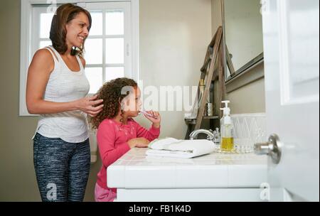 Mutter und Tochter im Bad am Waschbecken die Zähne putzen Stockfoto