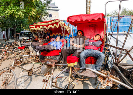 Rikschafahrer eine Pause nach der Einnahme von Touristen auf einer Tour in den Houhai Seen Region Beijing China Stockfoto