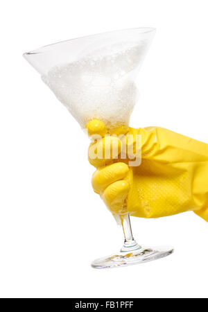 Nahaufnahme von weiblicher Hand in gelben schützende Gummihandschuh hält sauber transparent Martini-Glas in Schaum gegen weiß Stockfoto