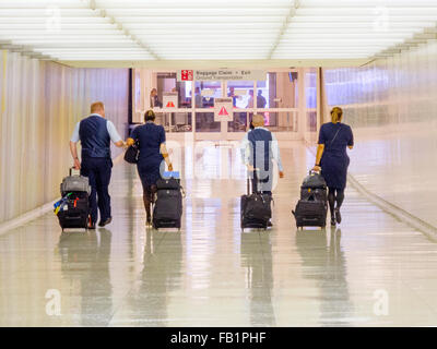 Tragen ihres Gepäcks auf rollenden Wagen, einen uniformierten Besatzungen Köpfe für die Ankunftshalle am Los Angeles International Airport, auch bekannt als LAX. Stockfoto