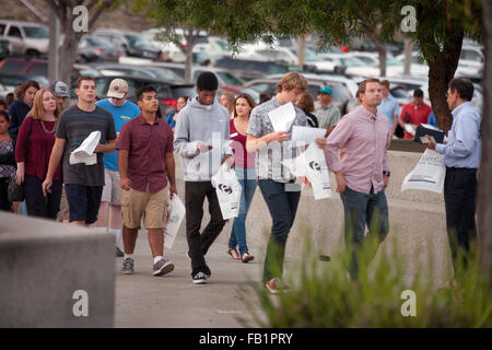 Kunststoff Tragetaschen für Literatur, kommen multirassische Schülerinnen und Schüler und Eltern an einem College Messe in Aliso Viejo, CA. beachten Sie volle Parkplatz im Hintergrund. Stockfoto
