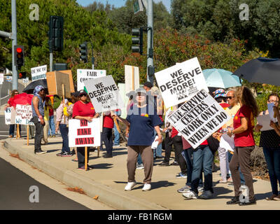 Gemischtrassige elektrische union Streikenden Streikposten einer US-Regierung Gebäude in Laguna Niguel, CA, Protestierende Mangel an geplanten Lohnerhöhungen. Stockfoto