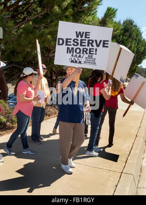 Gemischtrassige elektrische union Streikenden Streikposten einer US-Regierung Gebäude in Laguna Niguel, CA, Protestierende Mangel an geplanten Lohnerhöhungen. Stockfoto