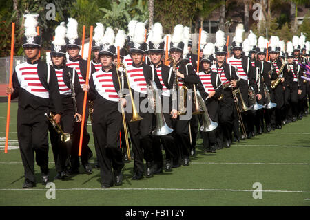 In voller Uniform und mit ihren Instrumenten nimmt eine multirassische High School marschierendes Band das Feld bei einem countywide Bandwettbewerb in Mission Viejo, Kalifornien. Stockfoto