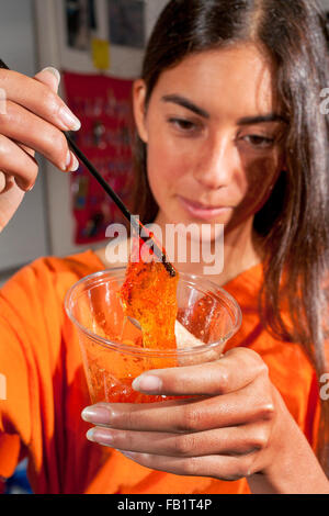 Eine Mischung aus Polyvinylalkohol und Kalium Borat mit orange Gemüse Farbe Ergebnisse in einen bunten querverbundene Polymer Schleim Veranschaulichung Wasserstoff-Bindung in einem San Clemente, CA, High-School-Chemie-Klasse hinzugefügt. Stockfoto