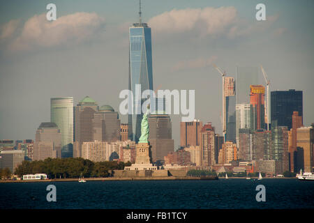 Die Freiheitsstatue auf Liberty Island im New Yorker Hafen ist One World Trade Center gegenüber aus Jersey City, NJ. Stockfoto