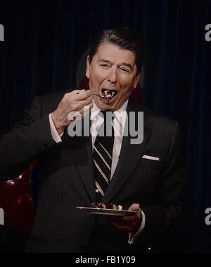 Washington, DC, USA, 6. Februar 1987 Präsident Ronald Reagan feiert seinen Geburtstag im Zimmer 450 OEOB. Genießt ein Stück Kuchen.  Bildnachweis: Mark Reinstein Stockfoto