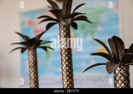 Kleine Palme Metall Baumschmuck vor Weltkarte Stockfoto