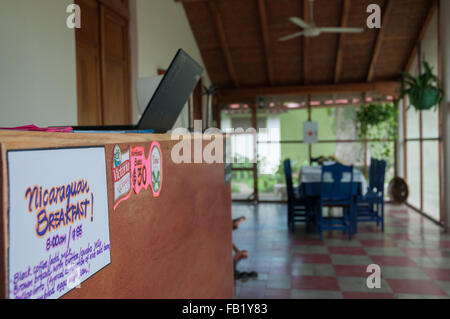 Lobby-Eingang eines niedlichen Hostels mit Laptop, Tisch, Stühle und ventilator Stockfoto