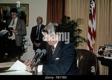 Washington DC, USA, 6. März 1985 Präsident Ronald Reagan sitzt an seinem Schreibtisch im Oval Office des weißen Hauses, Unterzeichnung der Veto-Nachricht für die Farm Credit und afrikanische Hunger Relief Bill Credit: Mark Reinstein Stockfoto