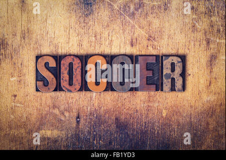 Das Wort "Fußball" in schmutzigen Vintage Buchdruck Typ auf einem alten hölzernen Hintergrund geschrieben. Stockfoto