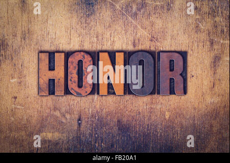 Das Wort "Ehre" in schmutzigen Vintage Buchdruck Typ auf einem alten hölzernen Hintergrund geschrieben. Stockfoto