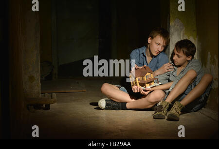 Kleine Jungs in einem dunklen Keller Stockfoto