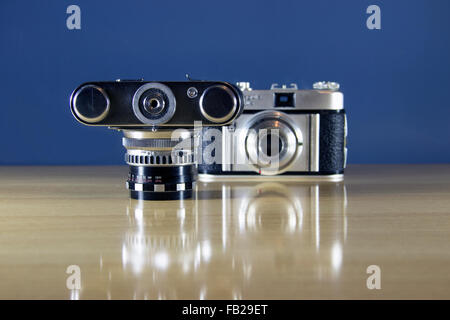 Zwei alte analoge 35mm-Kameras auf einem Holztisch präsentiert Stockfoto