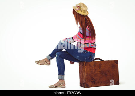Hipster-Frau sitzt auf dem Koffer Stockfoto