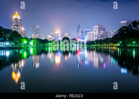 See und Hochhäuser in der Nacht, am Lumphini-Park in Bangkok, Thailand. Stockfoto