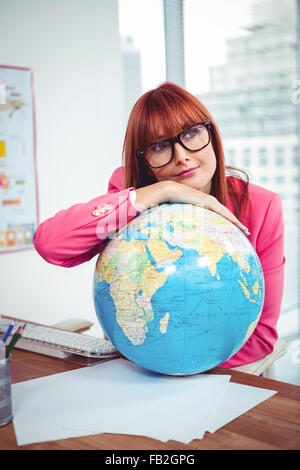Stütze dich auf einem Globus Hipster Geschäftsfrau Stockfoto