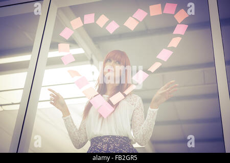 Lächelnde Hipster Frau tut ein Herz in Post-it Stockfoto