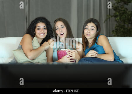 Drei Freunde, die romantischen Film im Fernsehen sitzt auf einer Couch zu Hause Stockfoto