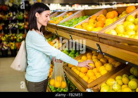 Porträt einer lächelnden Frau kaufen Orangen Stockfoto