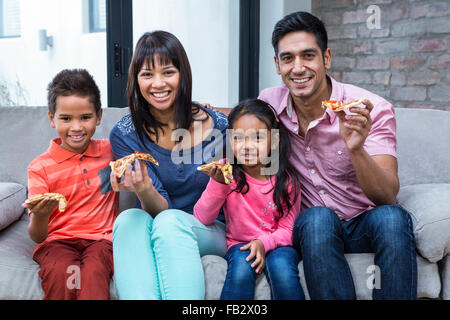 Glückliche Familie Essen Pizza auf dem sofa Stockfoto