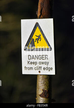 "Gefahr fernhalten Klippe". Warnschild am Baum. Falls of Clyde, Bonnington, South Lanarkshire, Schottland, Großbritannien, Europa. Stockfoto