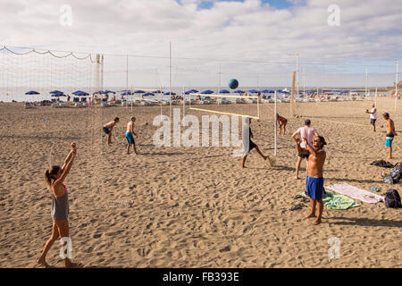 Gruppen von Jugendlichen spielen Beach-Volleyball am Strand Las Vistas in Los Cristianos, Teneriffa, Kanarische Inseln, Spanien. Stockfoto