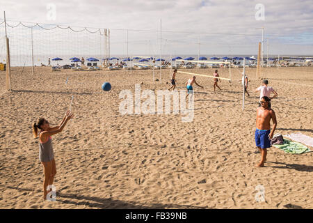 Gruppen von Jugendlichen spielen Beach-Volleyball am Strand Las Vistas in Los Cristianos, Teneriffa, Kanarische Inseln, Spanien. Stockfoto