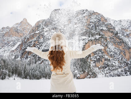 Magische Mischung aus Wintersaison und Berg Landschaft schaffen die perfekte Stimmung. Gesehen von hinten junge Frau in weißem Fell und Pelz Stockfoto