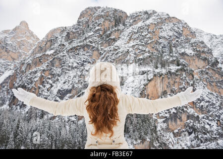 Magische Mischung aus Wintersaison und Berg Landschaft schaffen die perfekte Stimmung. Gesehen von hinten Frau in weißem Fell und Pelzhut re Stockfoto