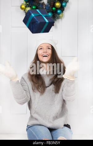 Mädchen auf den Türschwellen Standortwahl und Box mit Geschenk in die Luft werfen Stockfoto