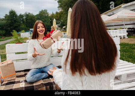 Mädchen wirft Geschenke zueinander Stockfoto