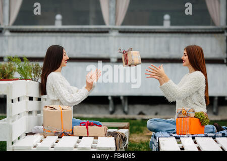 Mädchen wirft Geschenke zueinander Stockfoto