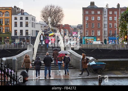 DUBLIN, Irland - Januar 05: Fußgänger zu Fuß über die Ha'penny Brücke an einem regnerischen Tag. Die Brücke ist der Hauptzugang zu th Stockfoto