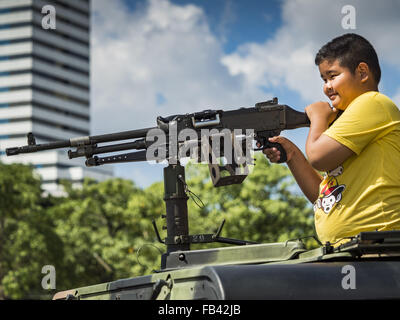 Bangkok, Thailand. 9. Januar 2016. Ein Thai junge spielt mit einem Maschinengewehr Armee während der Kinder Tag Festlichkeiten in der Royal Thai Army Palastwache, 2. Division Kavallerie Basis in Bangkok. Nationaler Kindertag fällt am zweiten Samstag des Jahres. Thailändische Regierungsagenturen Kind freundlich Events sponsern und das Militär in der Regel öffnet Militärbasen für Kinder, die kommen, um auf Panzer und Artilleriestücke spielen. Bildnachweis: Jack Kurtz/ZUMA Draht/Alamy Live-Nachrichten Stockfoto