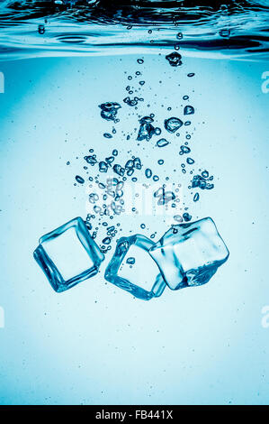 Eiswürfel ins Wasser sinken auf den Boden zu fallen. Zusammenfassung Hintergrund. Stockfoto