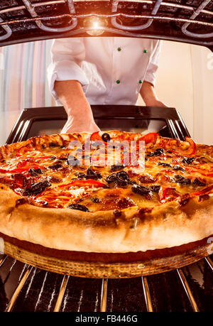 Chefkoch Pizza in den Ofen, Blick aus dem Inneren des Ofens. Kochen in den Ofen. Stockfoto