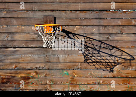 Basketball net wirft einen Schatten auf Holzwand Stockfoto