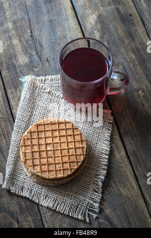 holländische Waffeln mit Karamell und Tee auf hölzernen Hintergrund Stockfoto