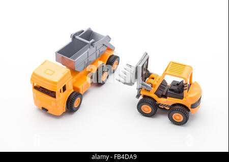 Zwei orange Spielzeug-Baufahrzeuge auf Plan zeichnen Hintergrund Stockfoto