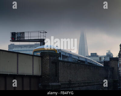 Ein Zug fährt von der London Bridge zur Waterloo Station in London mit dem Shard Wolkenkratzer in der Ferne Stockfoto