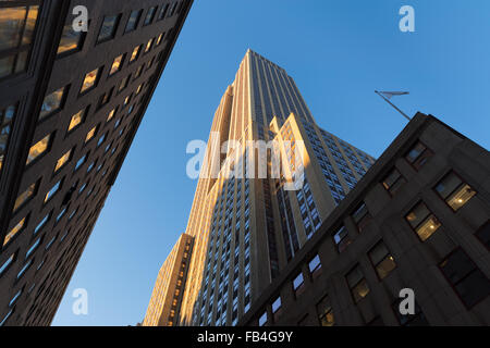 Empire State Building bei Sonnenuntergang von unten. Niedrigen Winkel auf der Art-Déco-Wolkenkratzer befindet sich in Midtown Manhattan, New York. Stockfoto