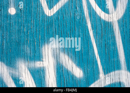 Vertikale Linien von Peeling blaue Farbe auf Holzwand mit weißem Sprühlack Markierungen Stockfoto