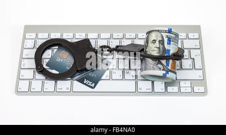 Stahl Handschellen, Kreditkarte und Dollar Bill liegend auf einer Computertastatur Stockfoto