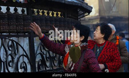 Kathmandu, Nepal. 9. Januar 2016. Chinesische Touristen drehen Gebetsmühlen während ihres Besuchs im Swayambhunath Stupa in Kathmandu, Nepal, 9. Januar 2016. Nepal erwartet mehr chinesischen Touristen in den kommenden Jahren als Visa-Gebühren verzichtet hatte, um das Himalaya-Land zur Förderung des Tourismus nach einem verheerenden Erdbeben zu besuchen. © Sunil Sharma/Xinhua/Alamy Live-Nachrichten Stockfoto